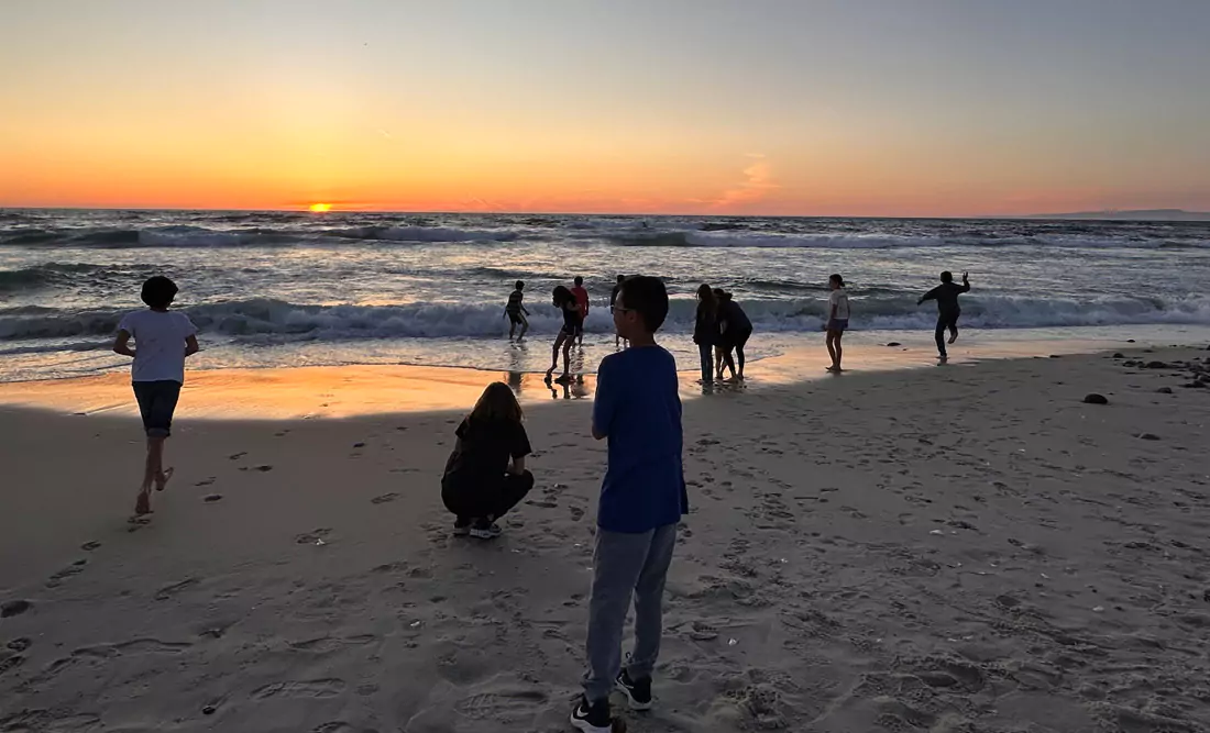 A sunset at Asilomar State Beach in Pacific Grove with Middle School students having fun.
