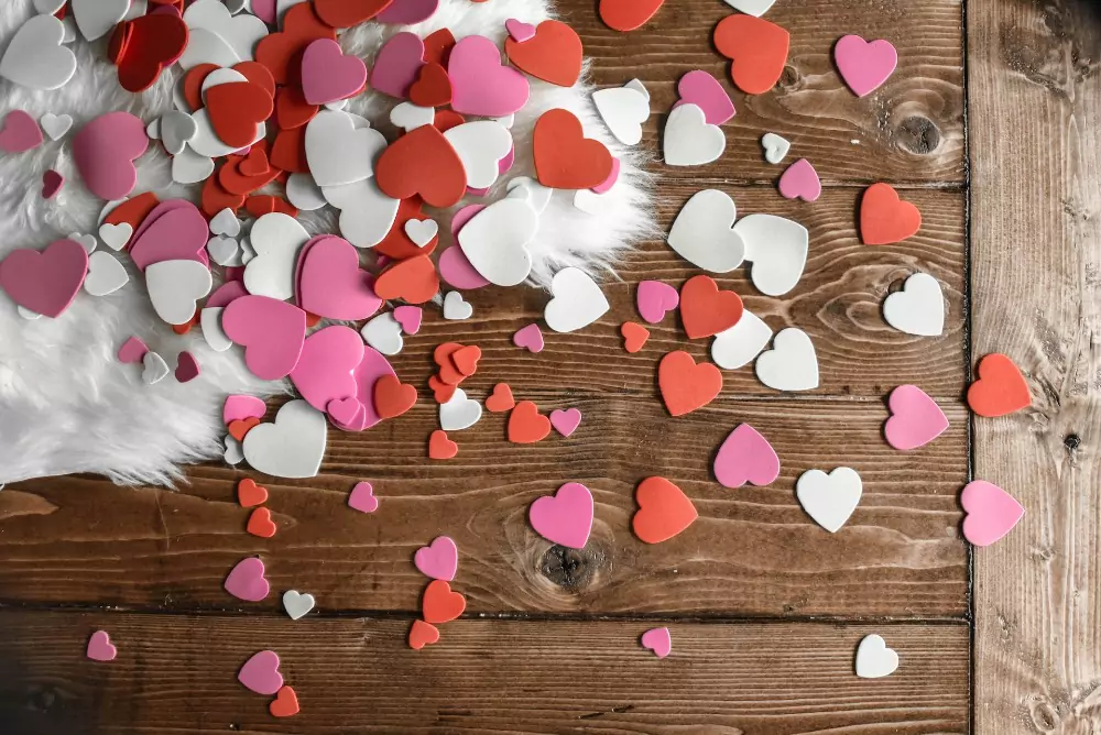 Valentine confetti on a wooden table. Photo by Element 5 Digital on Unsplash